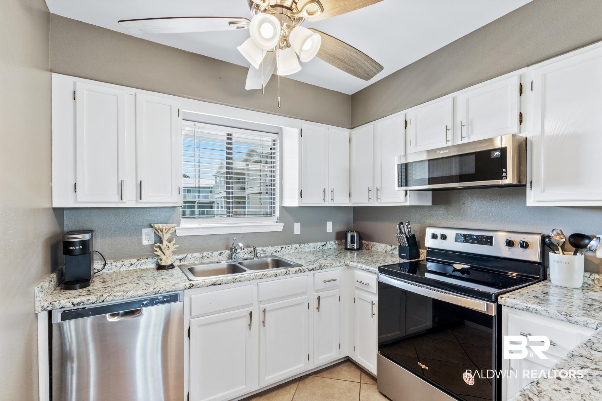 25925 -C Canal Road, Unit 203 Orange Beach, AL 36561 - Photo 7 of 57 Kitchen with white cabinets, ceiling fan, stainless steel appliances, and sink