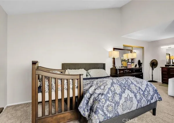 a bed sitting in a bedroom next to a window with tv
