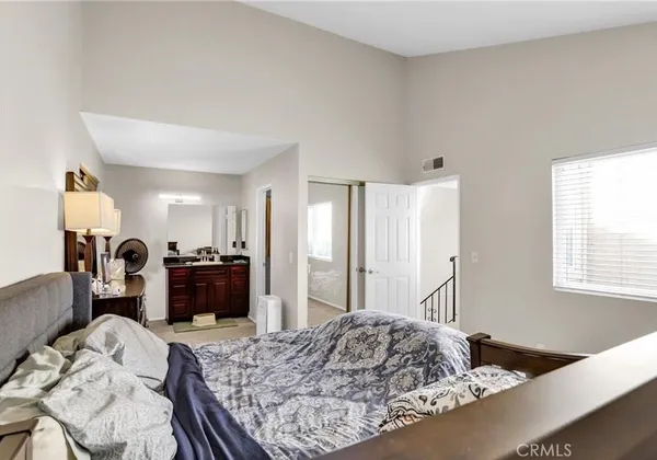 a bedroom with a bed and dresser with mirror