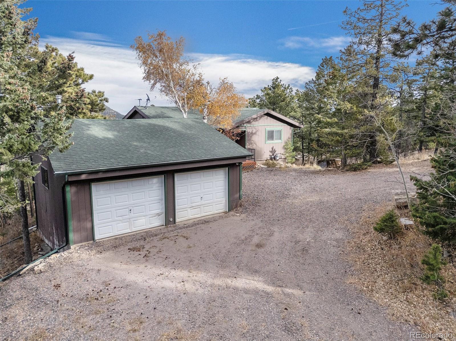 11540 Inspiration Road Golden, CO 80403 - Photo 24 of 33 a front view of a house with a yard and garage