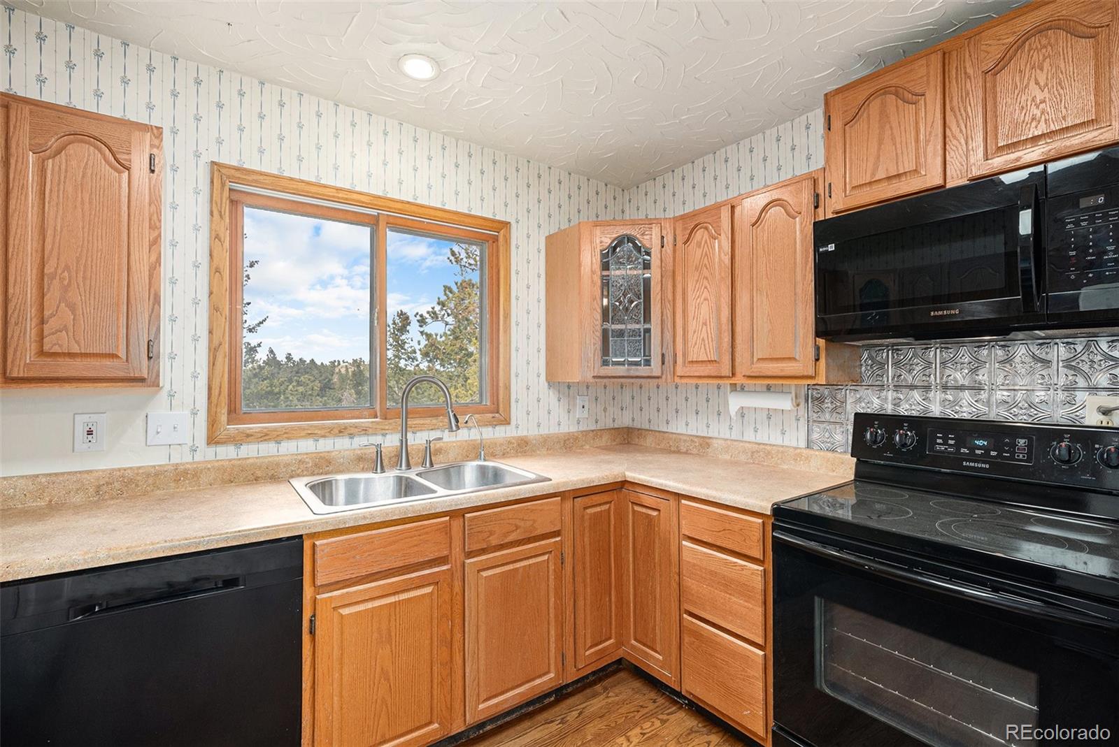 11540 Inspiration Road Golden, CO 80403 - Photo 9 of 33 a kitchen with stainless steel appliances a stove sink microwave and cabinets