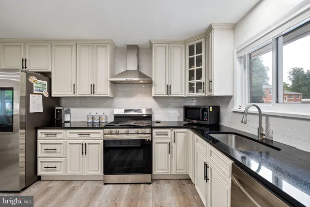 a kitchen with stainless steel appliances granite countertop a stove and a sink