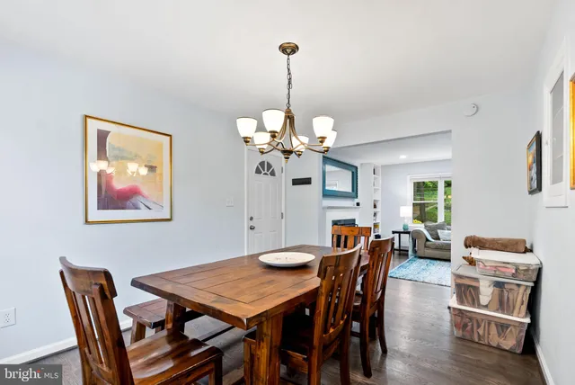 a view of a dining room with furniture a chandelier and wooden floor