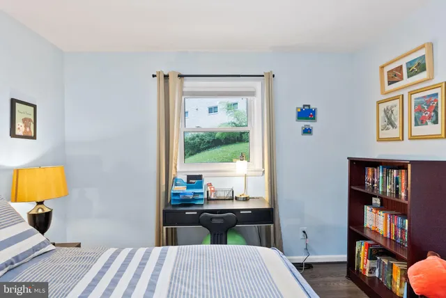 a bedroom with a bed a window and potted plant
