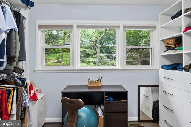 a kitchen with stainless steel appliances kitchen island granite countertop a refrigerator a stove a dining table and chairs with wooden floor