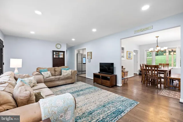 a dining room with furniture a chandelier and wooden floor