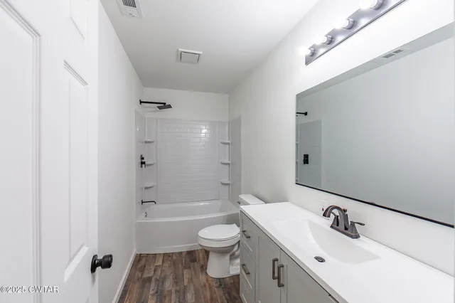 a bathroom with a bathtub shower sink and toilet