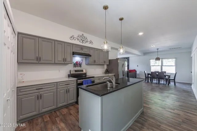 a kitchen with sink stove and cabinets
