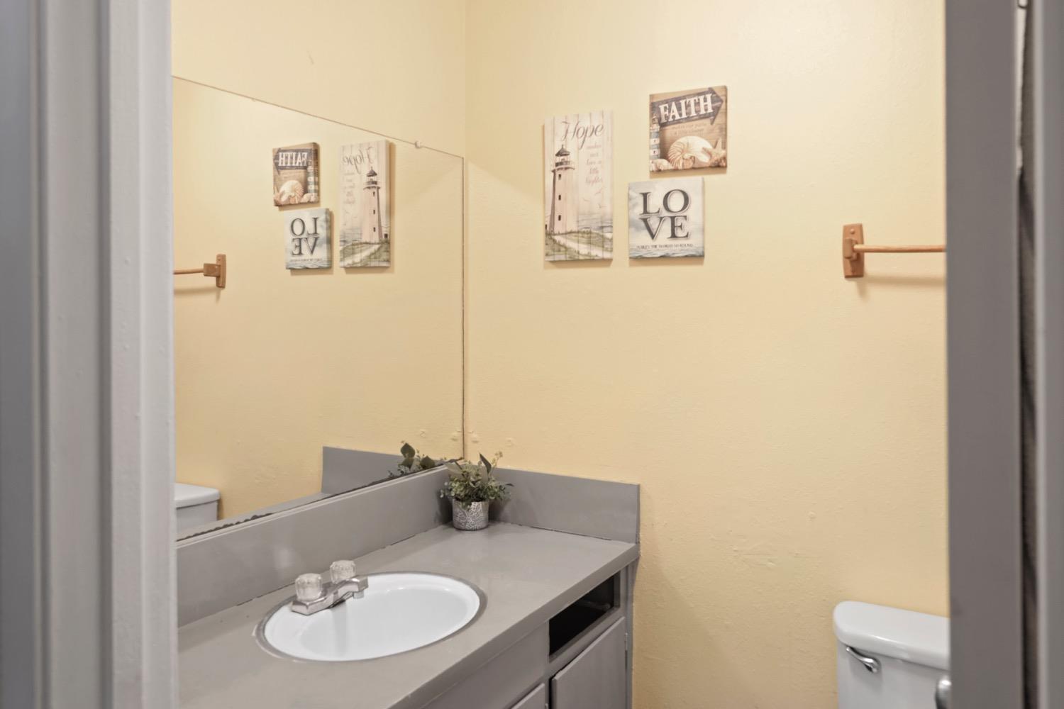 948 Harvard Avenue Clovis, CA 93612 - Photo 13 of 26 a bathroom with a sink vanity mirror and toilet