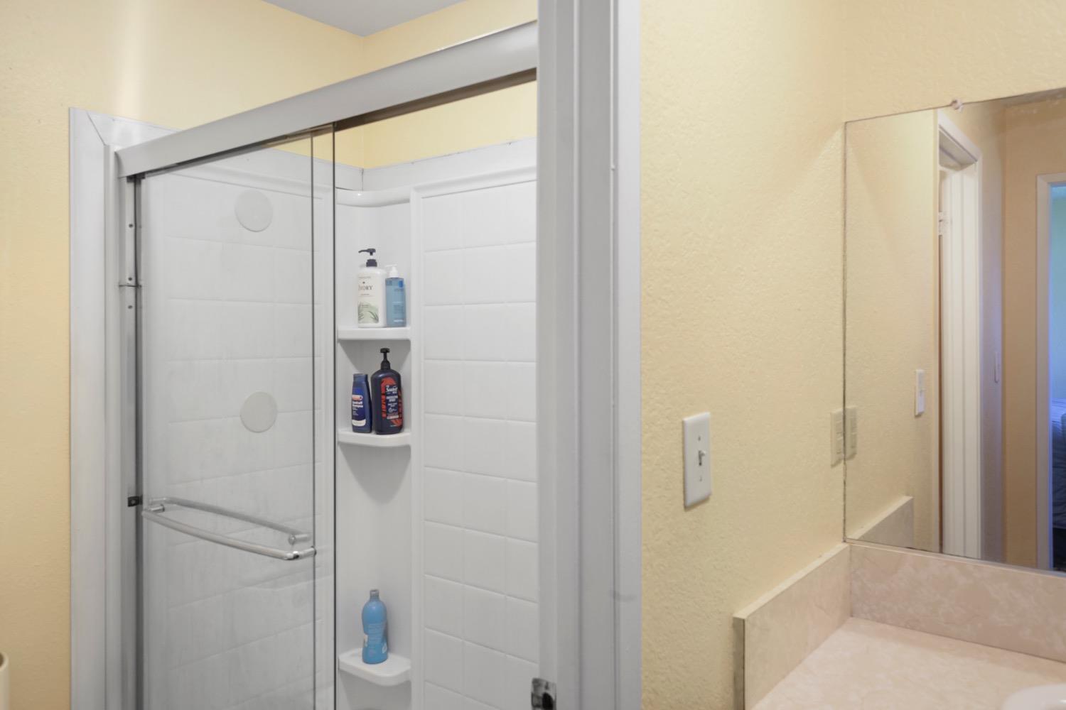 948 Harvard Avenue Clovis, CA 93612 - Photo 21 of 26 a bathroom with a shower and a glass door