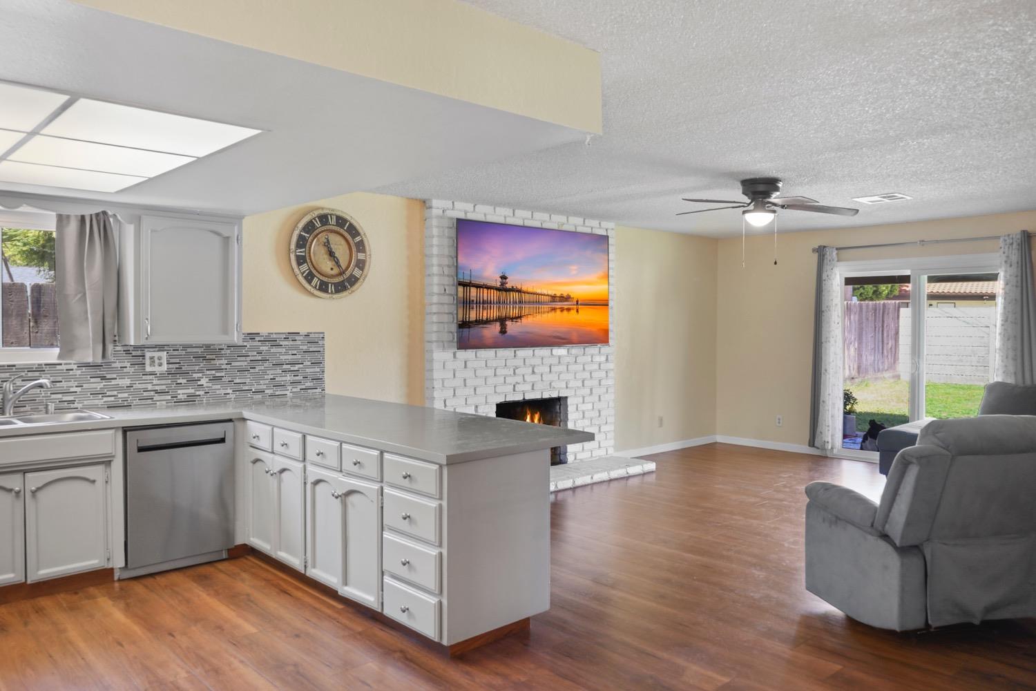 948 Harvard Avenue Clovis, CA 93612 - Photo 4 of 26 a living room with stainless steel appliances granite countertop furniture a fireplace and a large window
