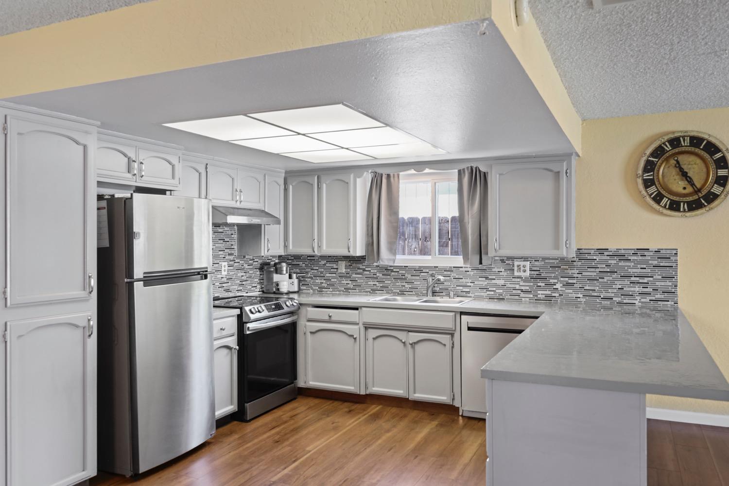 948 Harvard Avenue Clovis, CA 93612 - Photo 5 of 26 a kitchen with a sink a refrigerator and cabinets