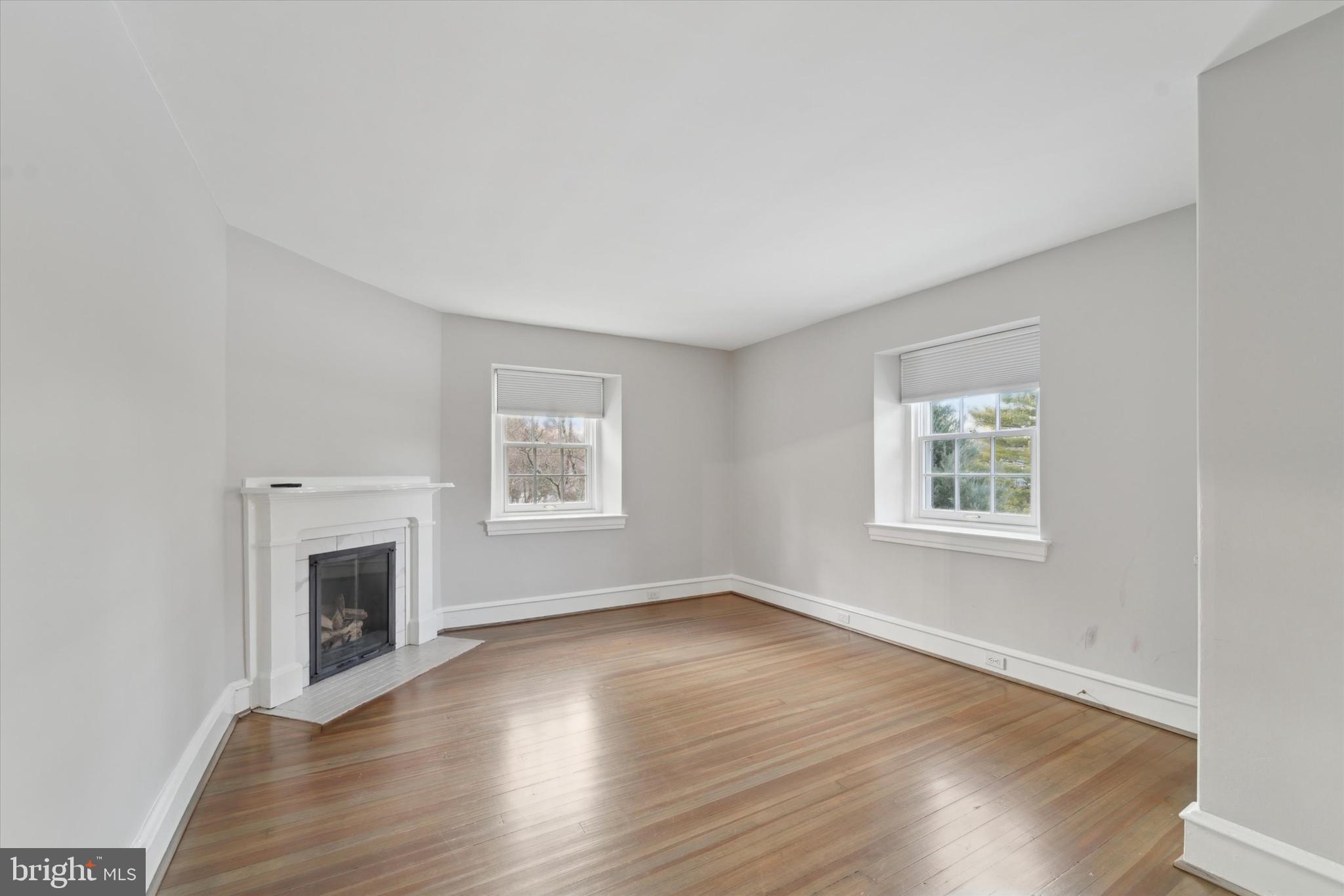 101 East Brookhaven Road Wallingford, PA 19086 - Photo 17 of 60 an empty room with wooden floor a fireplace and windows