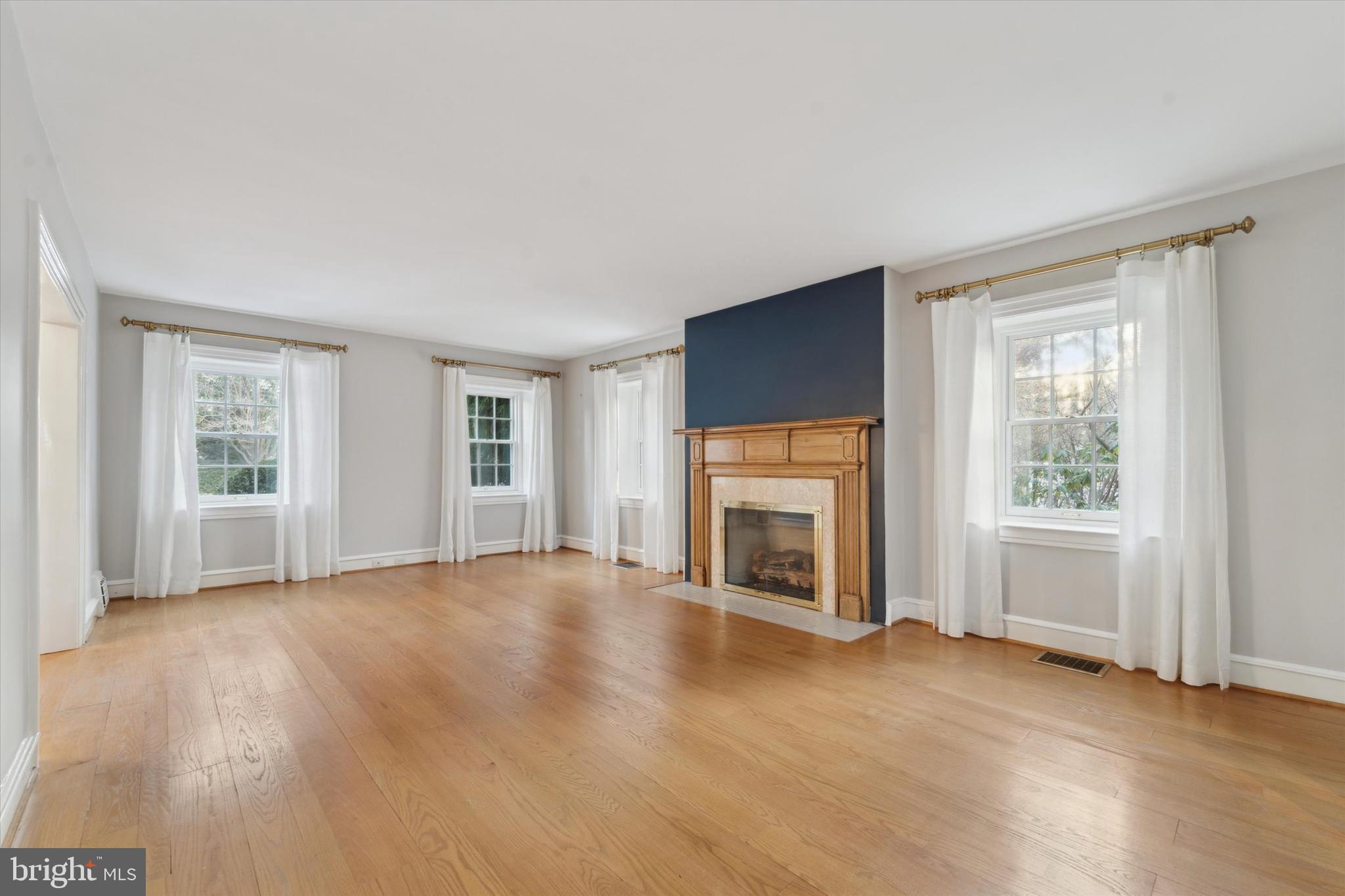 101 East Brookhaven Road Wallingford, PA 19086 - Photo 5 of 60 an empty room with windows fireplace and wooden floor