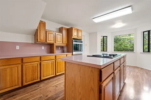 a kitchen with stainless steel appliances a stove a sink dishwasher and cabinets with wooden floor