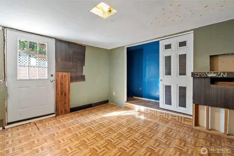 a view of a hallway with wooden floor and a bathroom