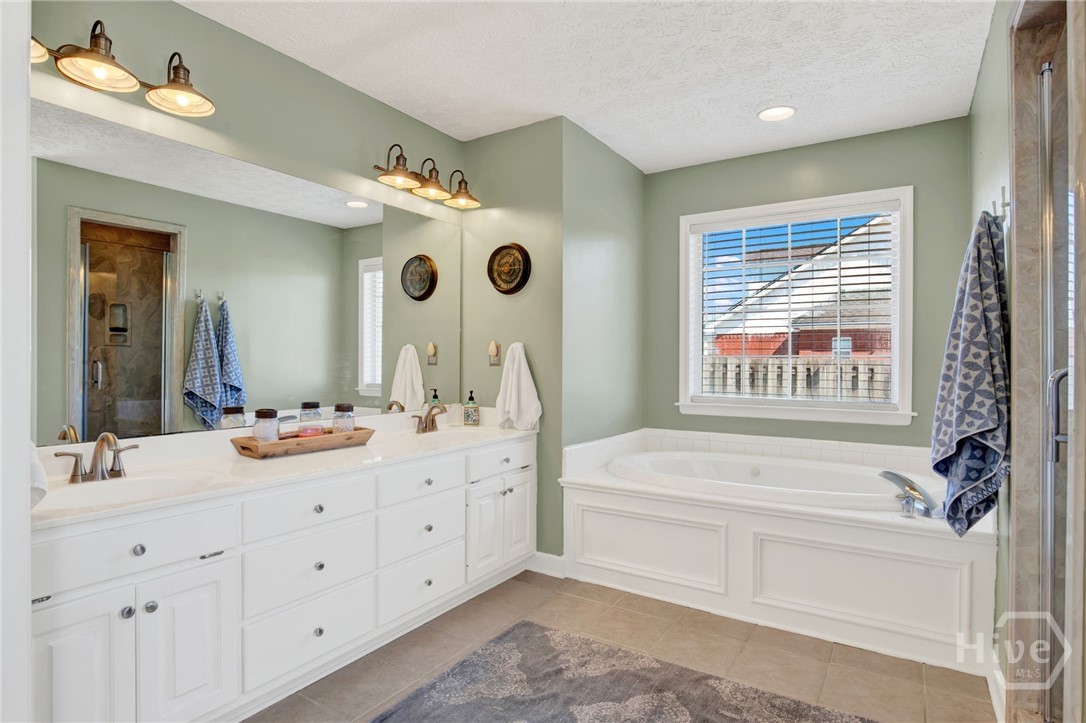 253 Scuffletown Road Guyton, GA 31312 - Photo 18 of 37 Primary bath featuring dual vanities, soaking tub, and separate walk-in shower.