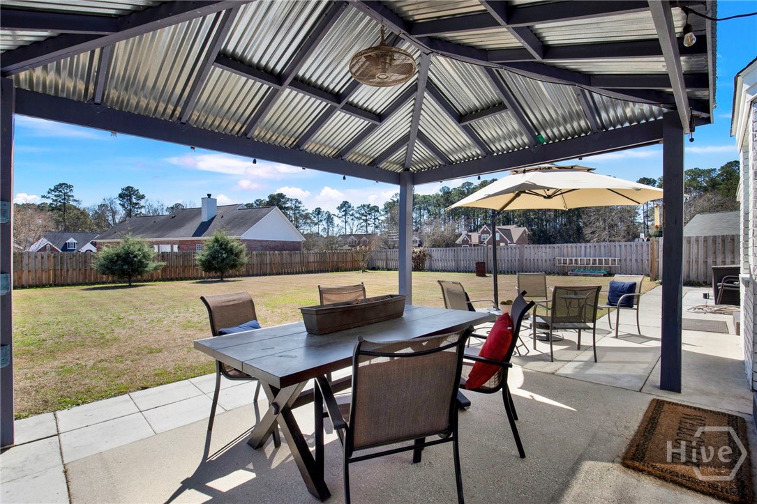 253 Scuffletown Road Guyton, GA 31312 - Photo 30 of 37 Spacious covered patio overlooking a large fenced backyard, ideal for outdoor dining and gatherings.