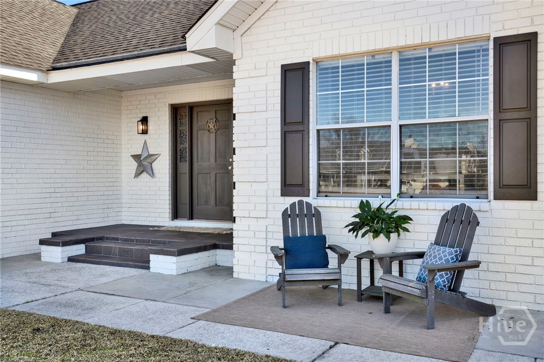 253 Scuffletown Road Guyton, GA 31312 - Photo 4 of 37 Inviting front porch with charming seating area and classic brick exterior details.