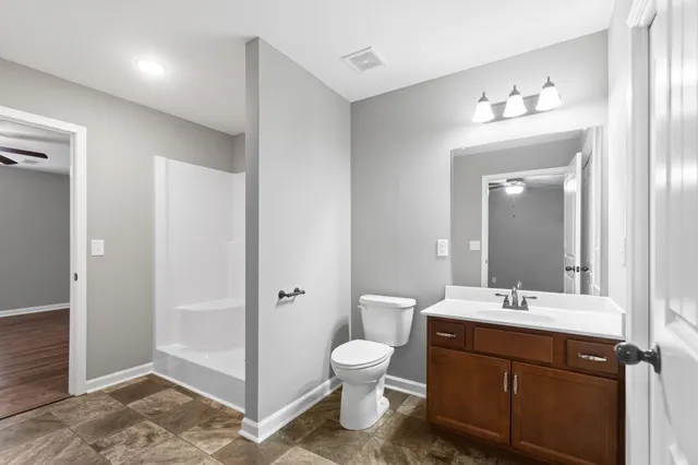 a bathroom with a toilet a sink and mirror