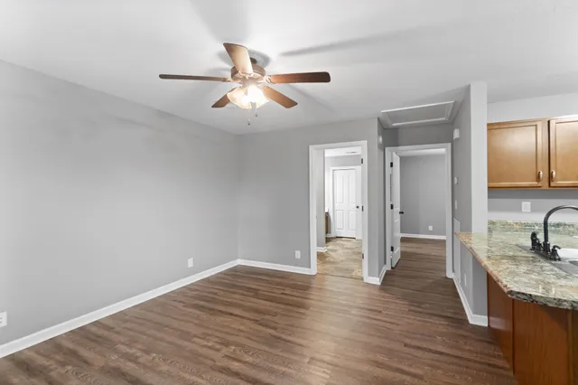 a view of empty room with wooden floor and window
