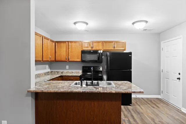 a kitchen with a sink a microwave a refrigerator and cabinets