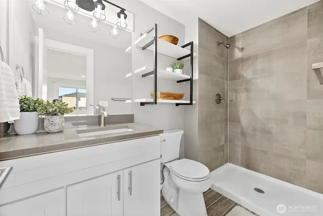 a bathroom with a sink a toilet and shower