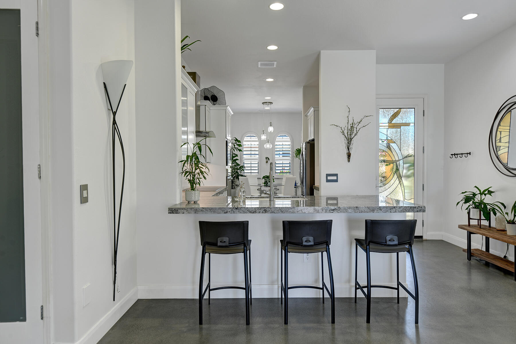 81881 Avenida Estuco Indio, CA 92203 - Photo 11 of 33 a kitchen with stainless steel appliances kitchen island granite countertop a dining table chairs and a refrigerator