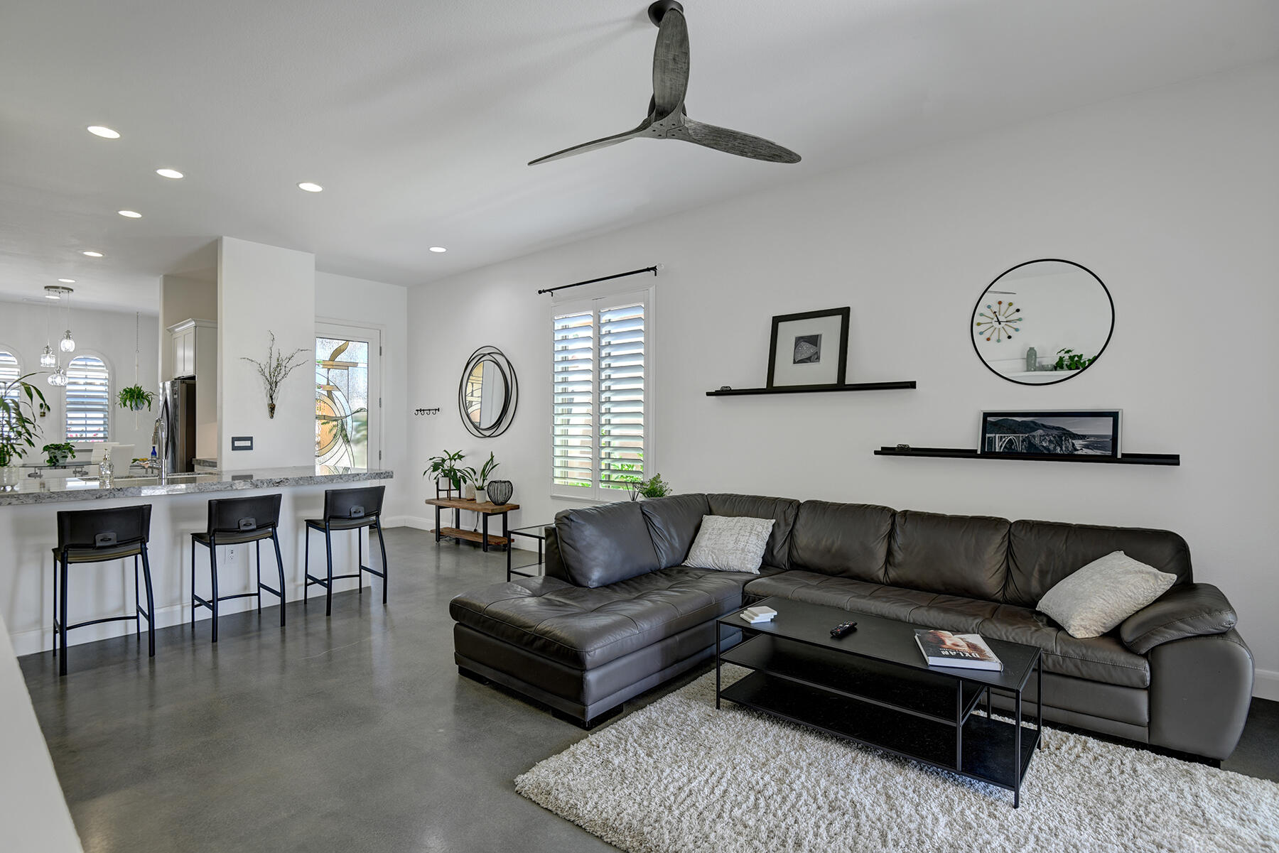 81881 Avenida Estuco Indio, CA 92203 - Photo 12 of 33 a living room with furniture a clock and a table
