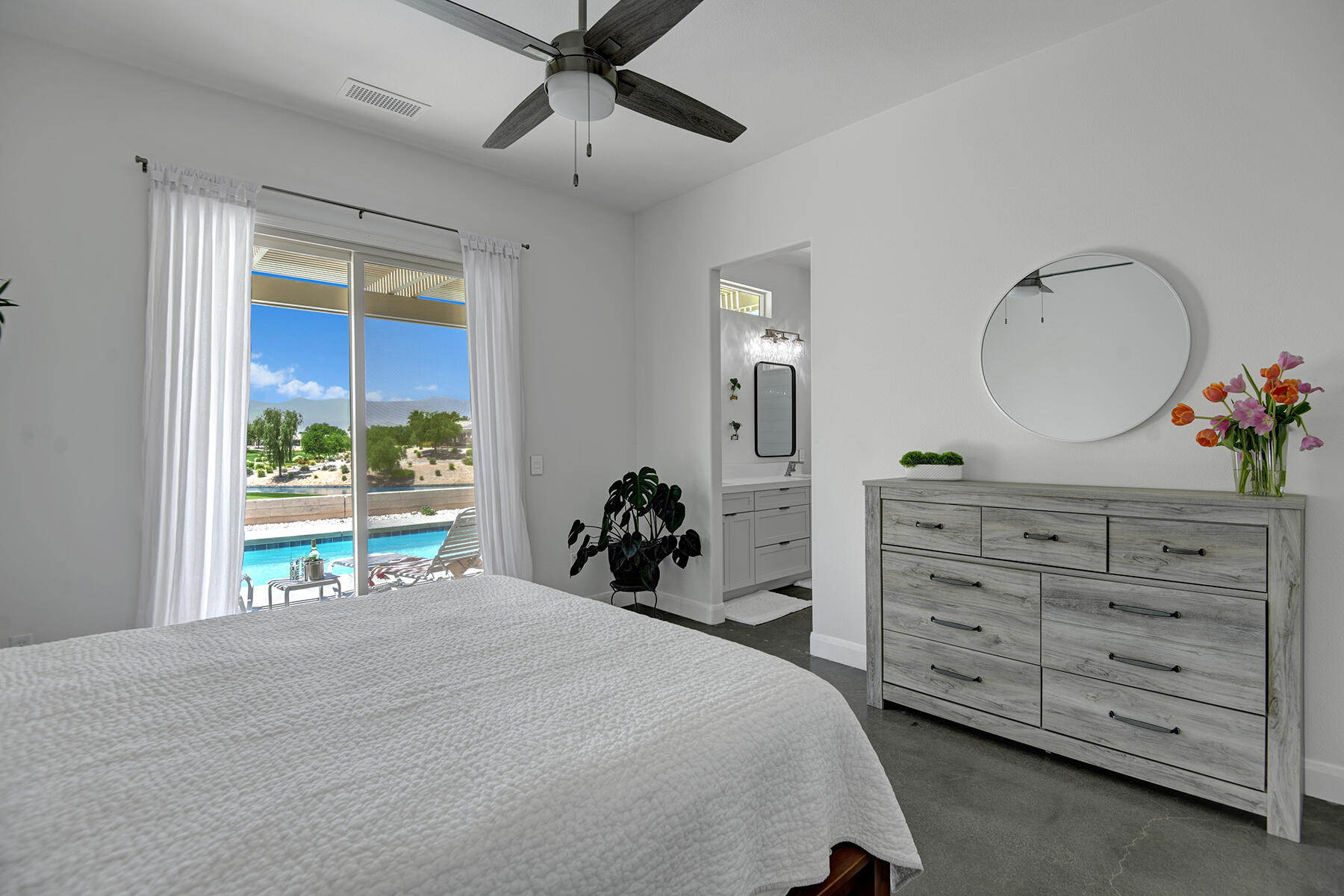 81881 Avenida Estuco Indio, CA 92203 - Photo 19 of 33 a bedroom with a bed and a large window