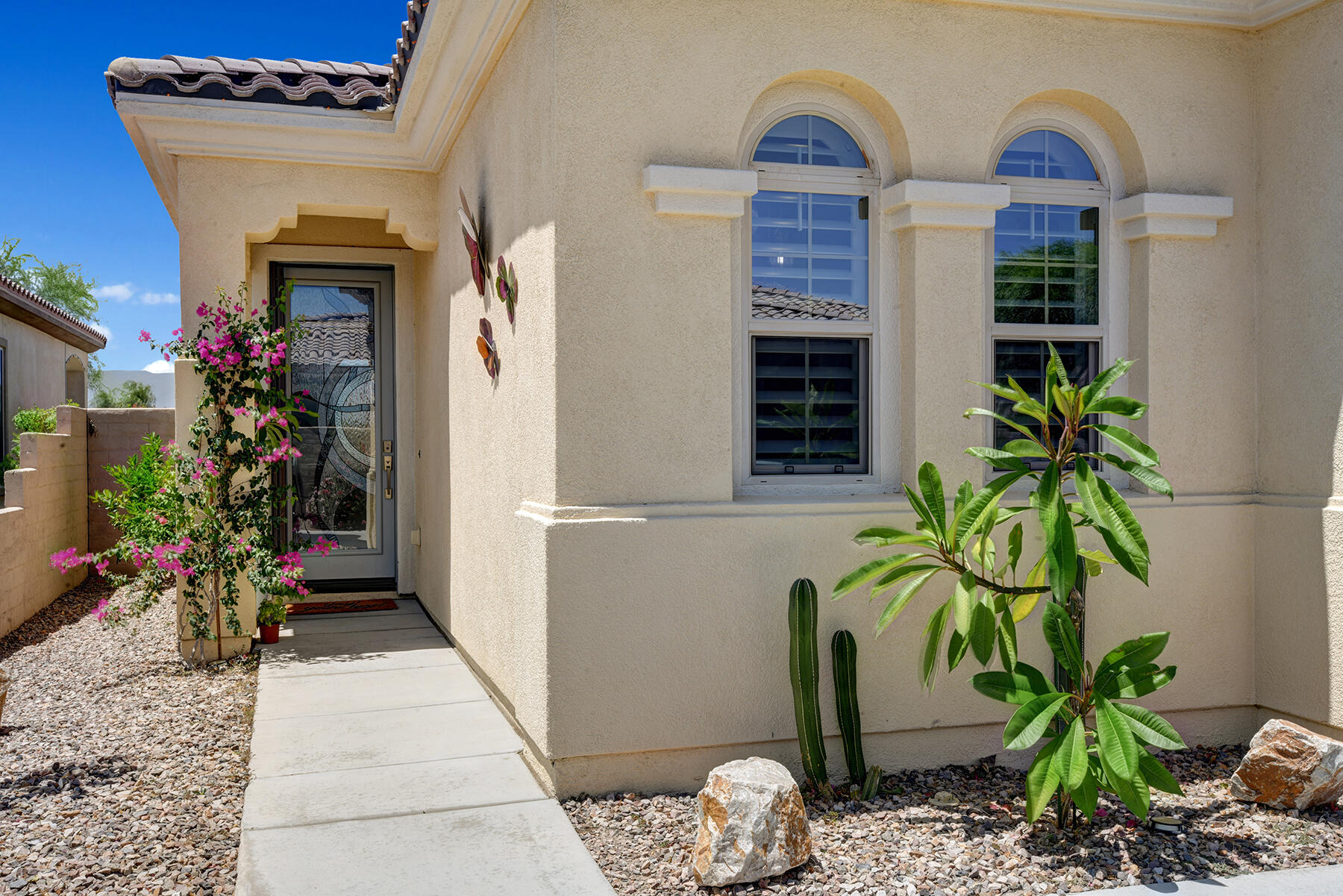 81881 Avenida Estuco Indio, CA 92203 - Photo 3 of 33 a vase with flowers sitting on a floor in front of a door