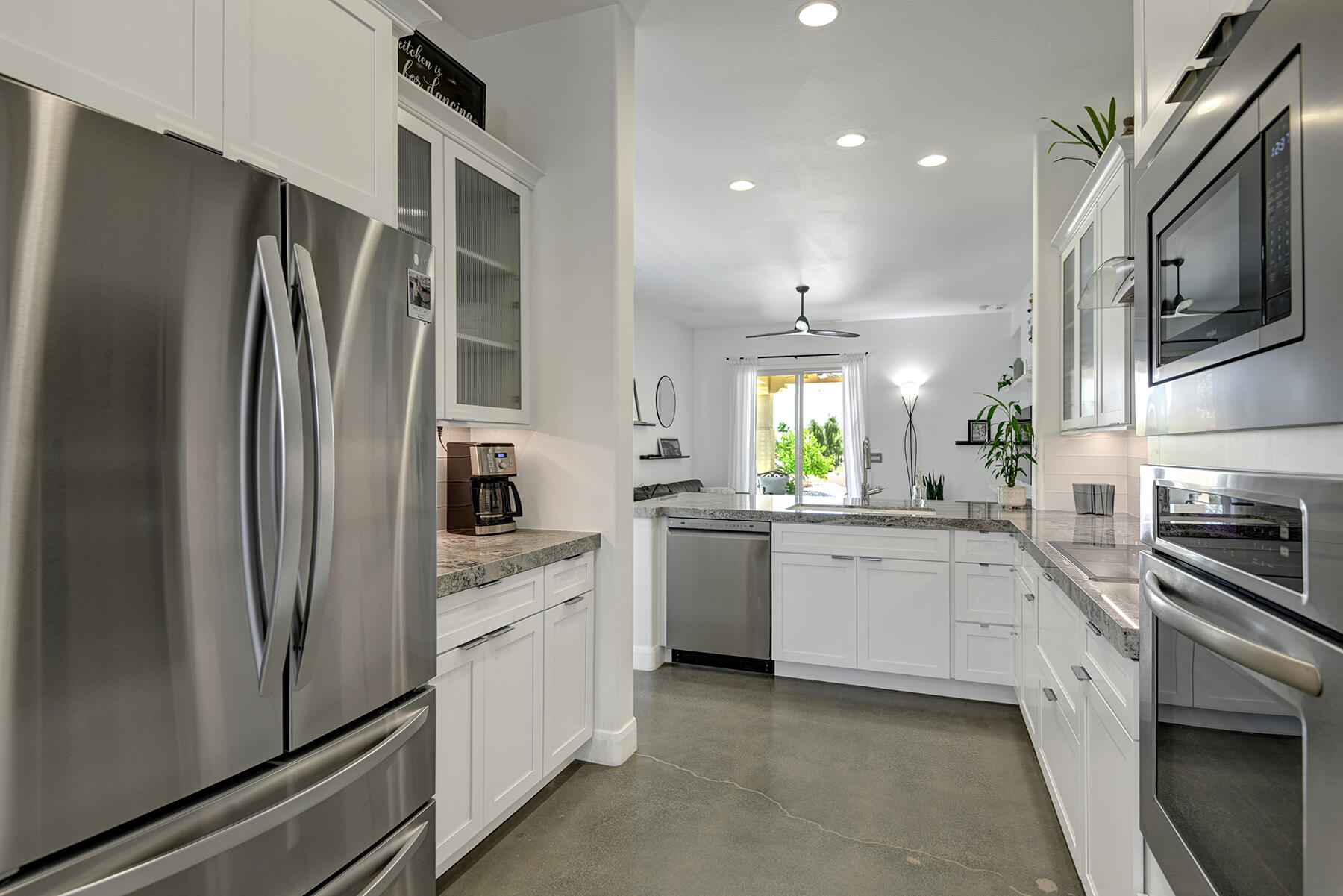 81881 Avenida Estuco Indio, CA 92203 - Photo 10 of 33 a kitchen with white cabinets and stainless steel appliances