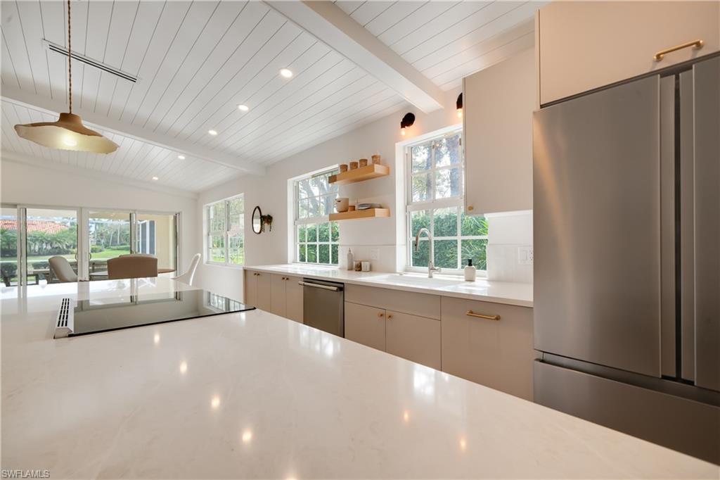 3695 El Segundo Court Naples, FL 34109 - Photo 18 of 37 Kitchen featuring vaulted ceiling with beams, recessed lighting, stainless steel appliances, light countertops, and open shelves