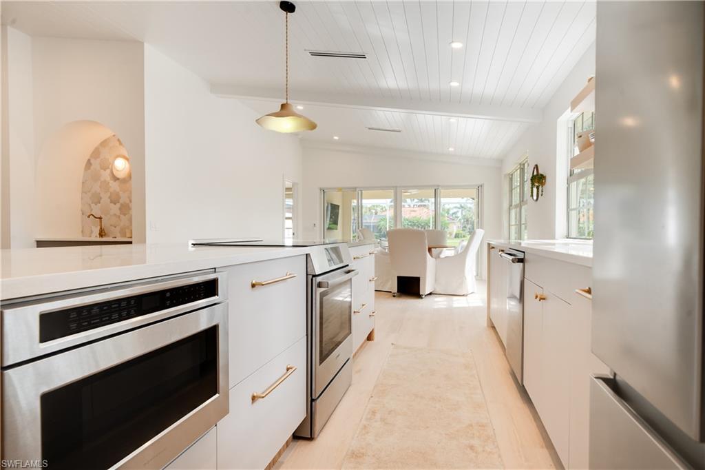 3695 El Segundo Court Naples, FL 34109 - Photo 2 of 37 Kitchen with modern cabinets, appliances with stainless steel finishes, decorative light fixtures, light countertops, and white cabinetry