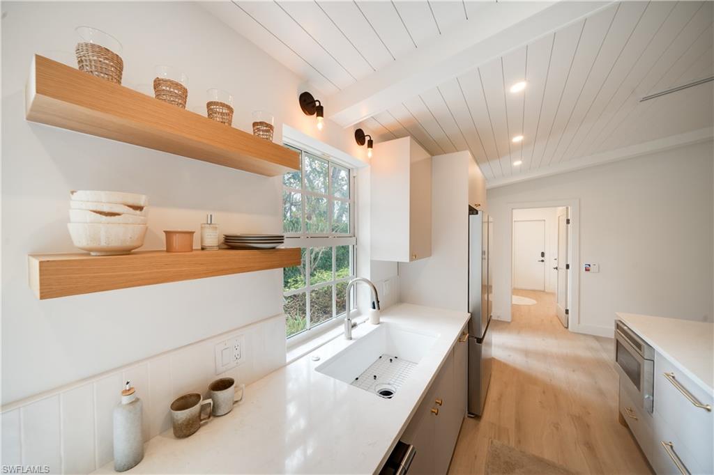 3695 El Segundo Court Naples, FL 34109 - Photo 5 of 37 Kitchen with light countertops, a sink, and open shelves