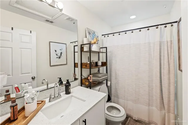 a bathroom with a sink a toilet and shower curtain