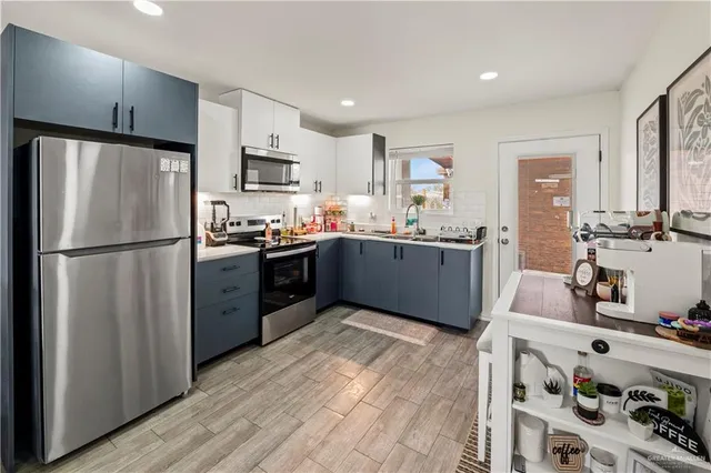 a kitchen with stainless steel appliances granite countertop a refrigerator and a sink