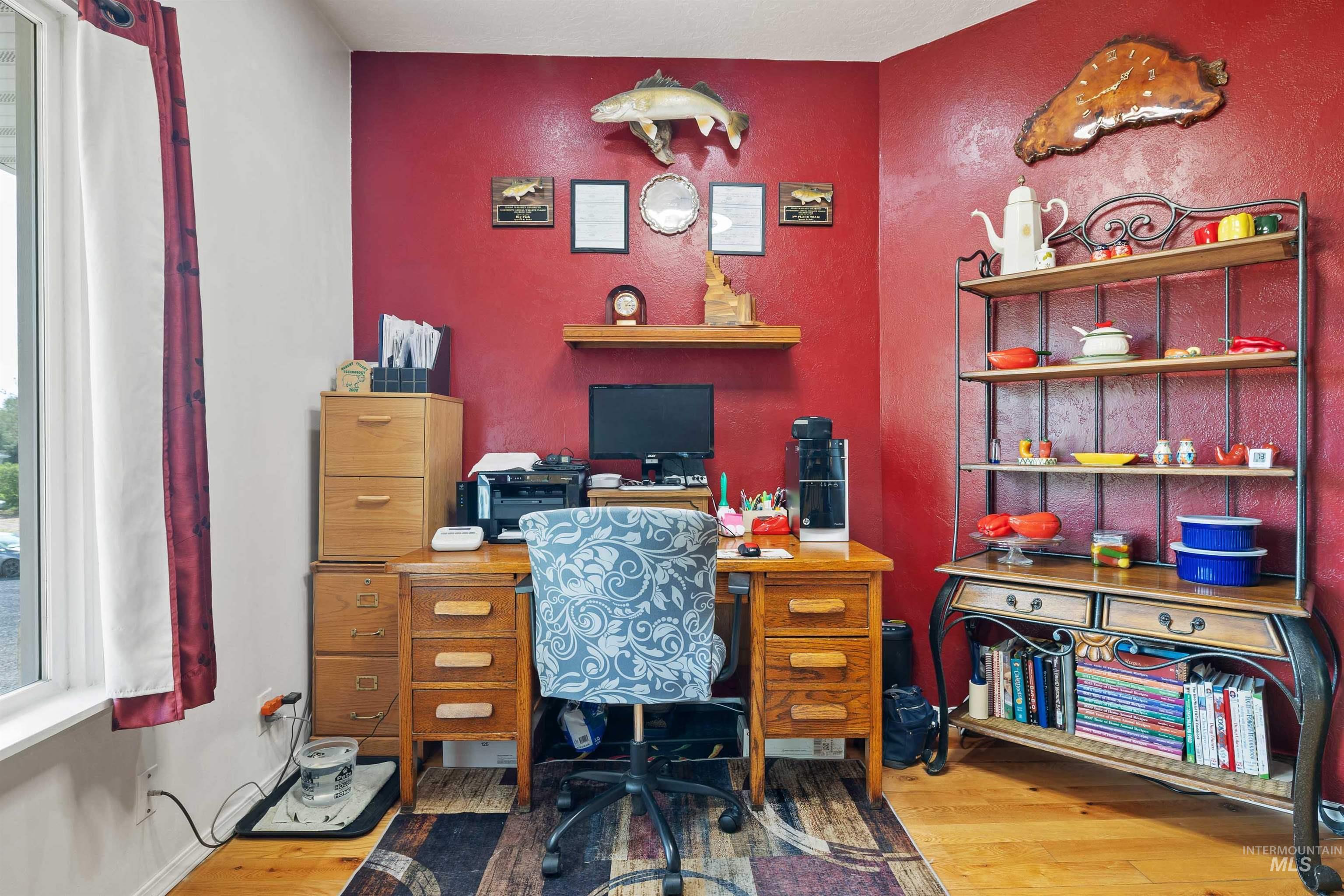 216 Ranch View Road West Jerome, ID 83338 - Photo 12 of 42 Warm-toned room featuring a corner desk area, wood-finish flooring, and a decorative shelving unit