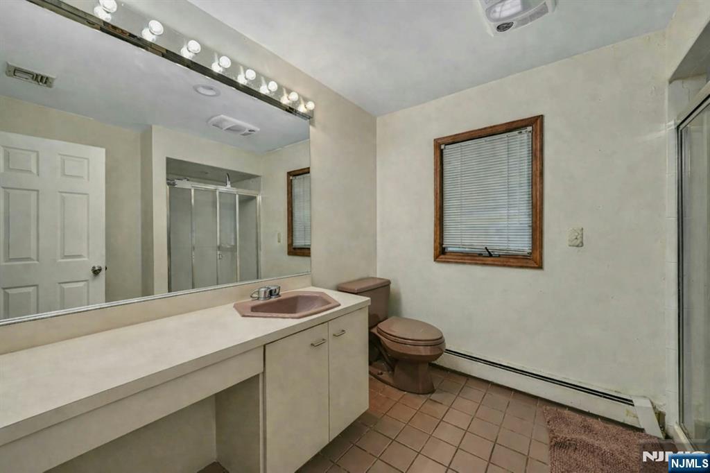 44 West Midland Avenue Paramus, NJ 07652 - Photo 19 of 19 a bathroom with a sink a toilet a mirror and vanity