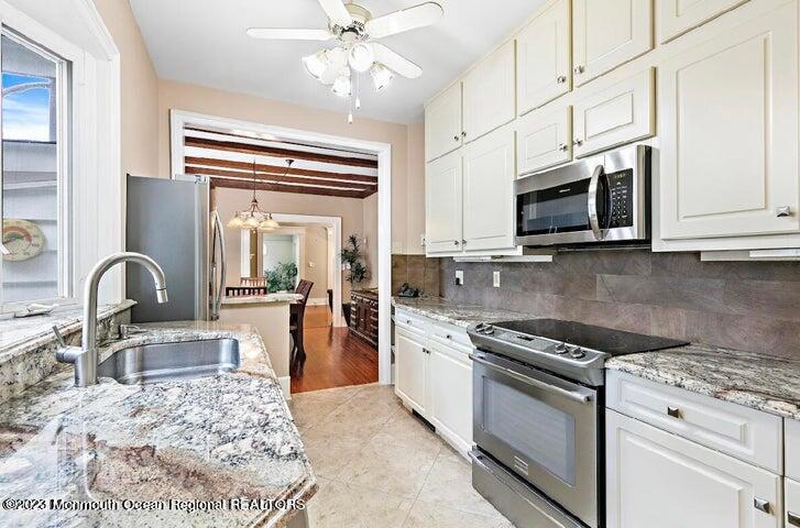214 Cliftwood Road Oakhurst, NJ 07755 - Photo 11 of 61 a kitchen with stainless steel appliances granite countertop a stove top oven a sink dishwasher a dining table and chairs with wooden floor
