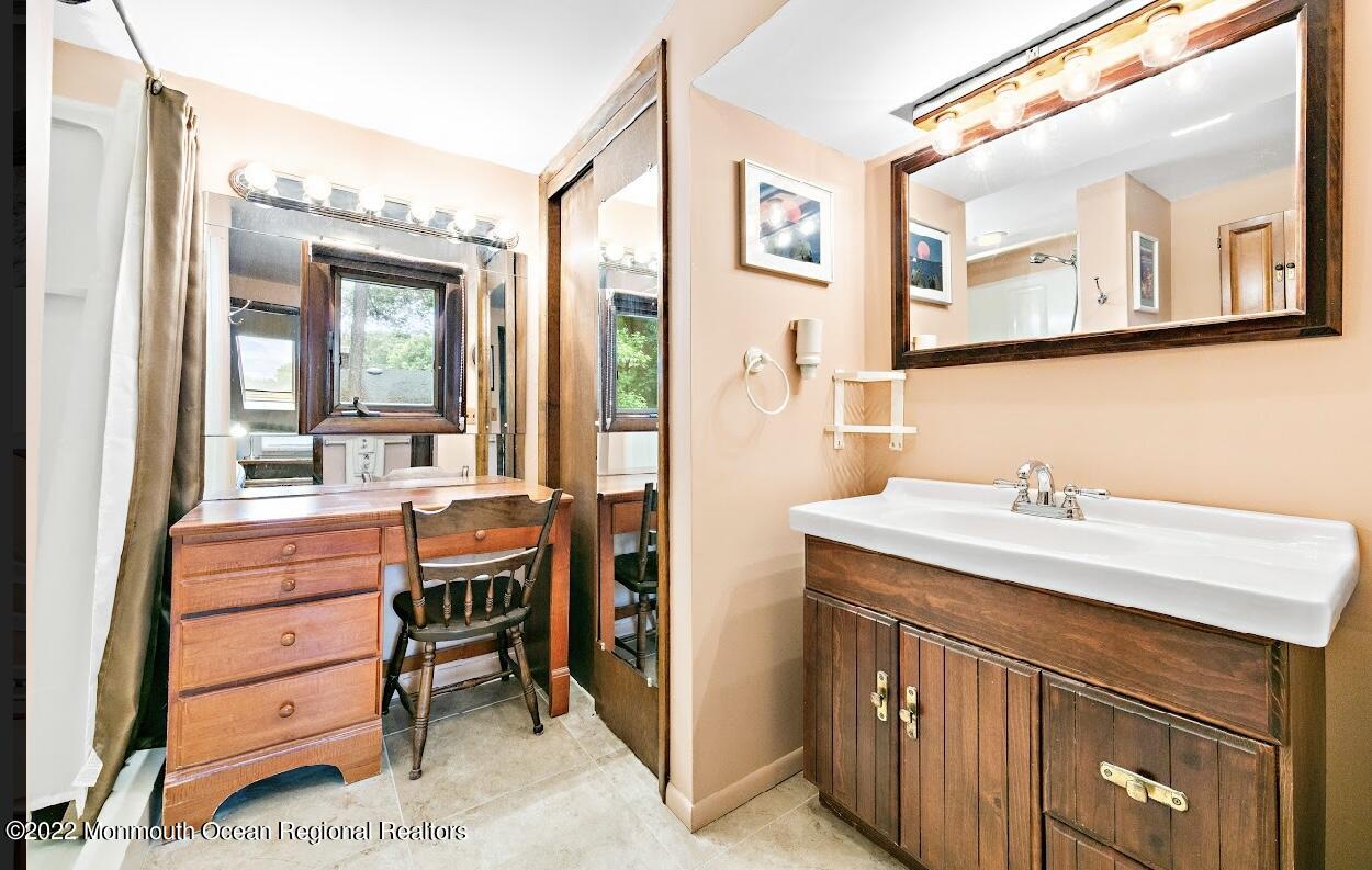 214 Cliftwood Road Oakhurst, NJ 07755 - Photo 28 of 61 a bathroom with a sink a mirror and a vanity
