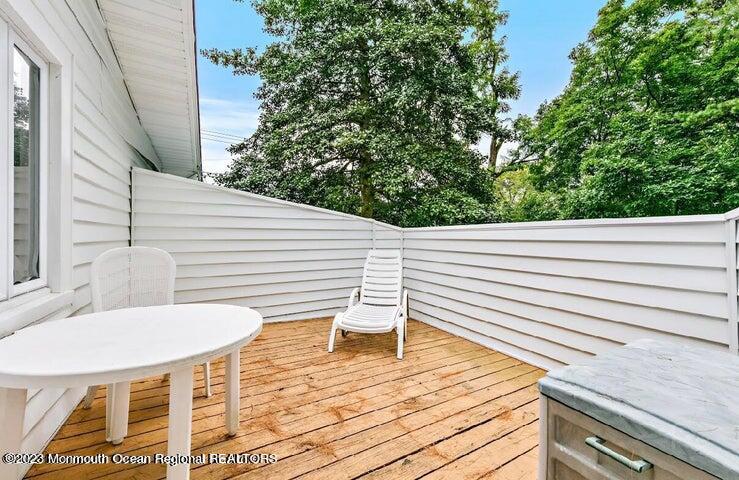 214 Cliftwood Road Oakhurst, NJ 07755 - Photo 31 of 61 a view of a patio with chair and table on the wooden floor