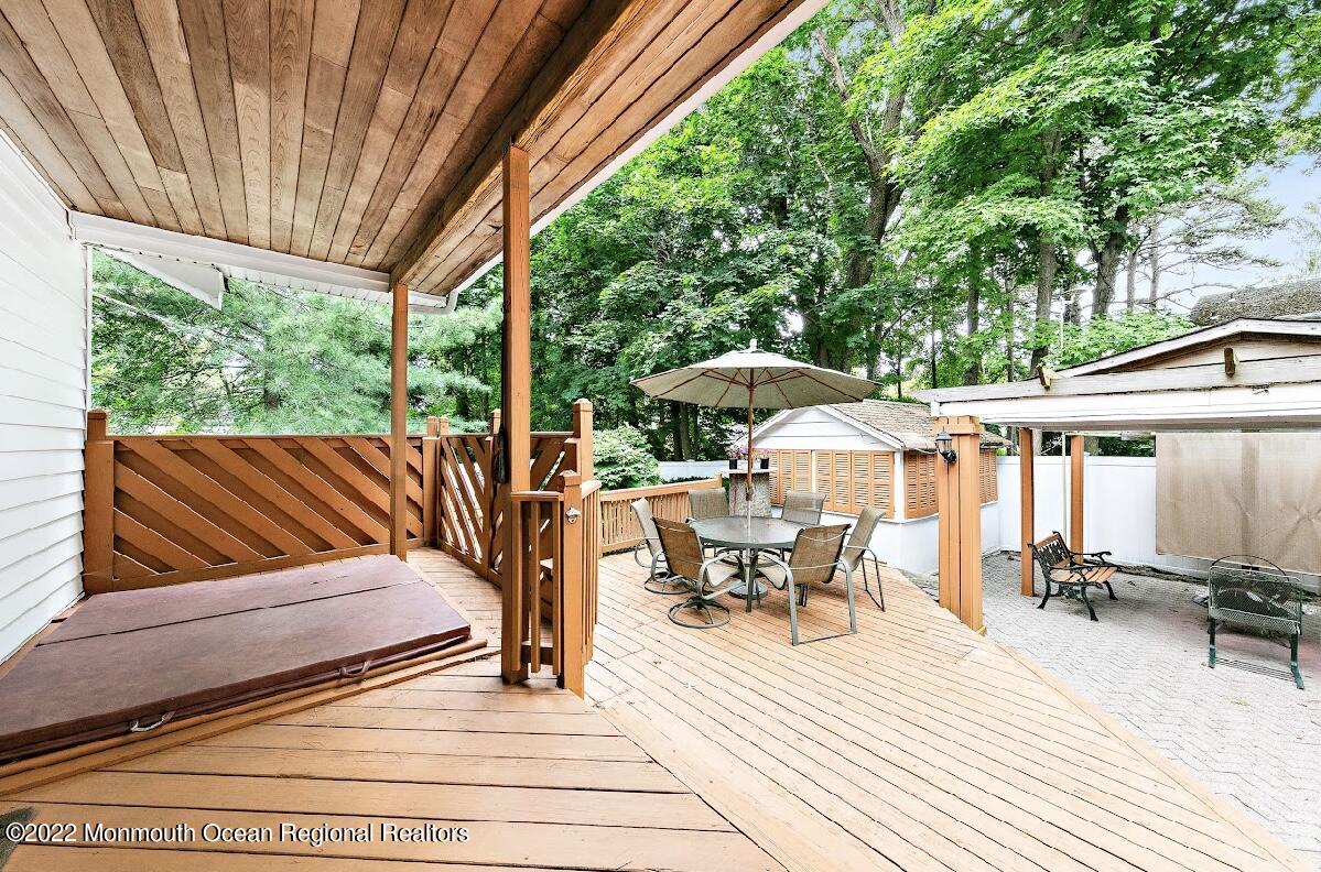 214 Cliftwood Road Oakhurst, NJ 07755 - Photo 46 of 61 a view of a patio with table and chairs under an umbrella with wooden floor and fence