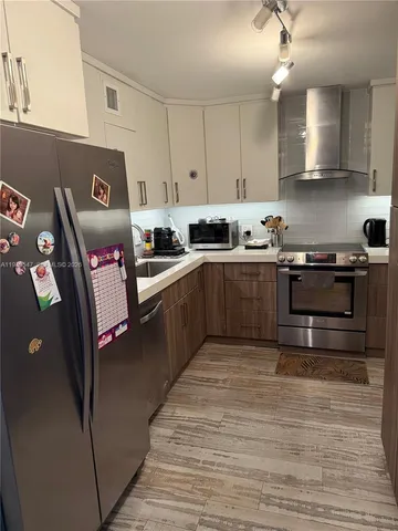 a kitchen with stainless steel appliances granite countertop a stove sink and cabinets