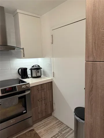 a kitchen with a refrigerator and a stove top oven
