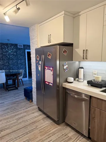 a kitchen with stainless steel appliances granite countertop a refrigerator and a stove