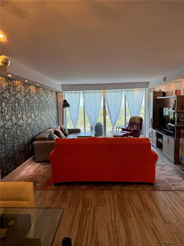 a living room with furniture and a floor to ceiling window