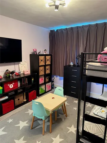 a living room with furniture a flat screen tv and a bookshelf