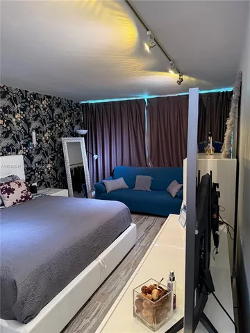 a bedroom with furniture and a flat screen tv