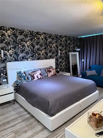 a bed sitting in a bedroom and wooden floor